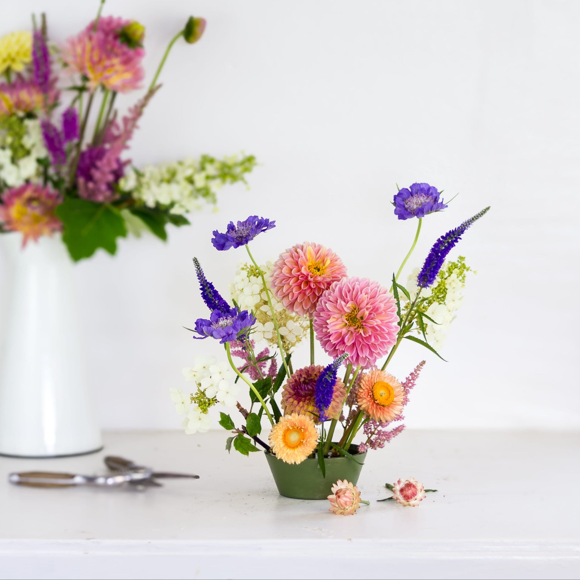 Brightly colored flowers in a green pin cup flower frog