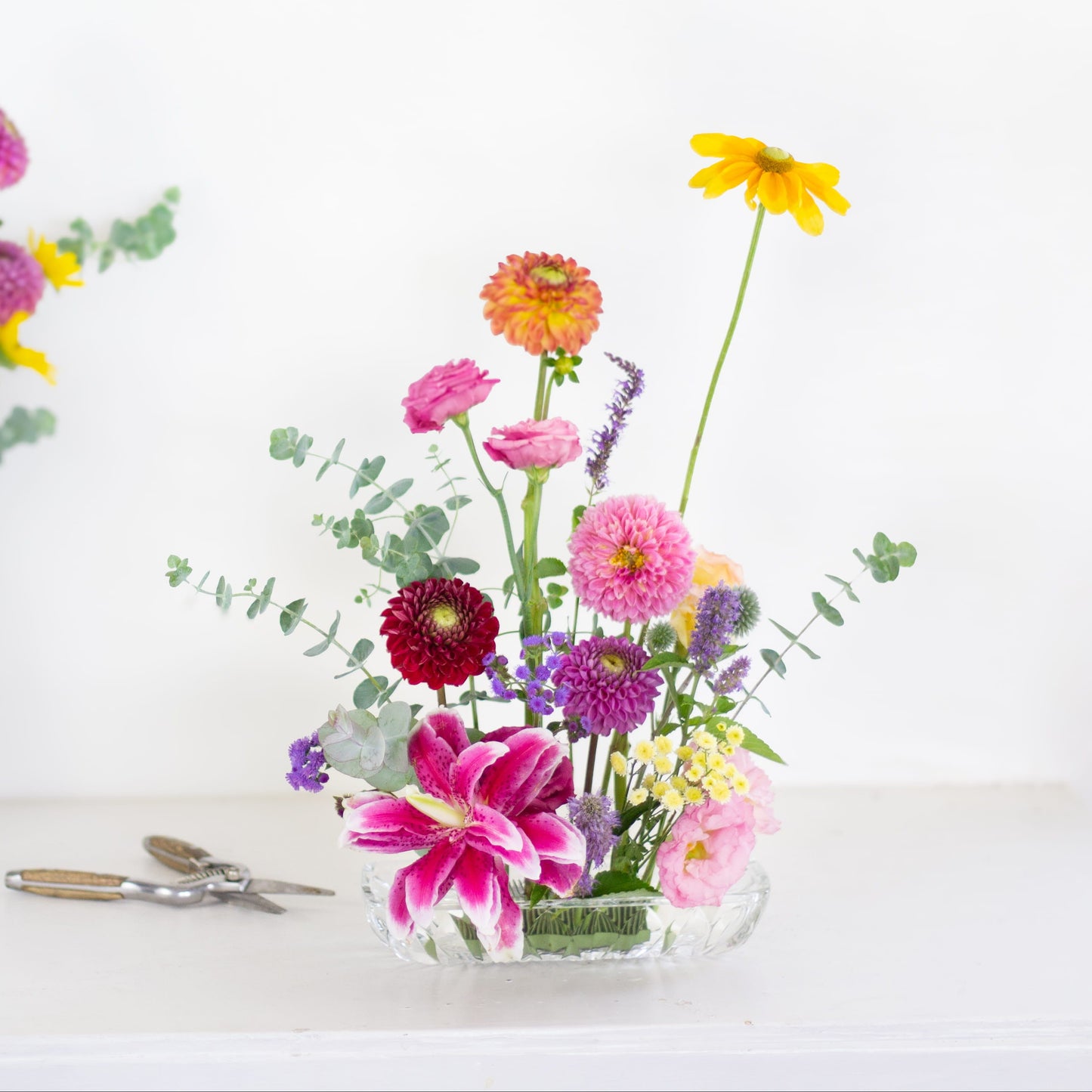 Rectangle pin holder kenzan flower frog in clear vase with brightly colored flowers